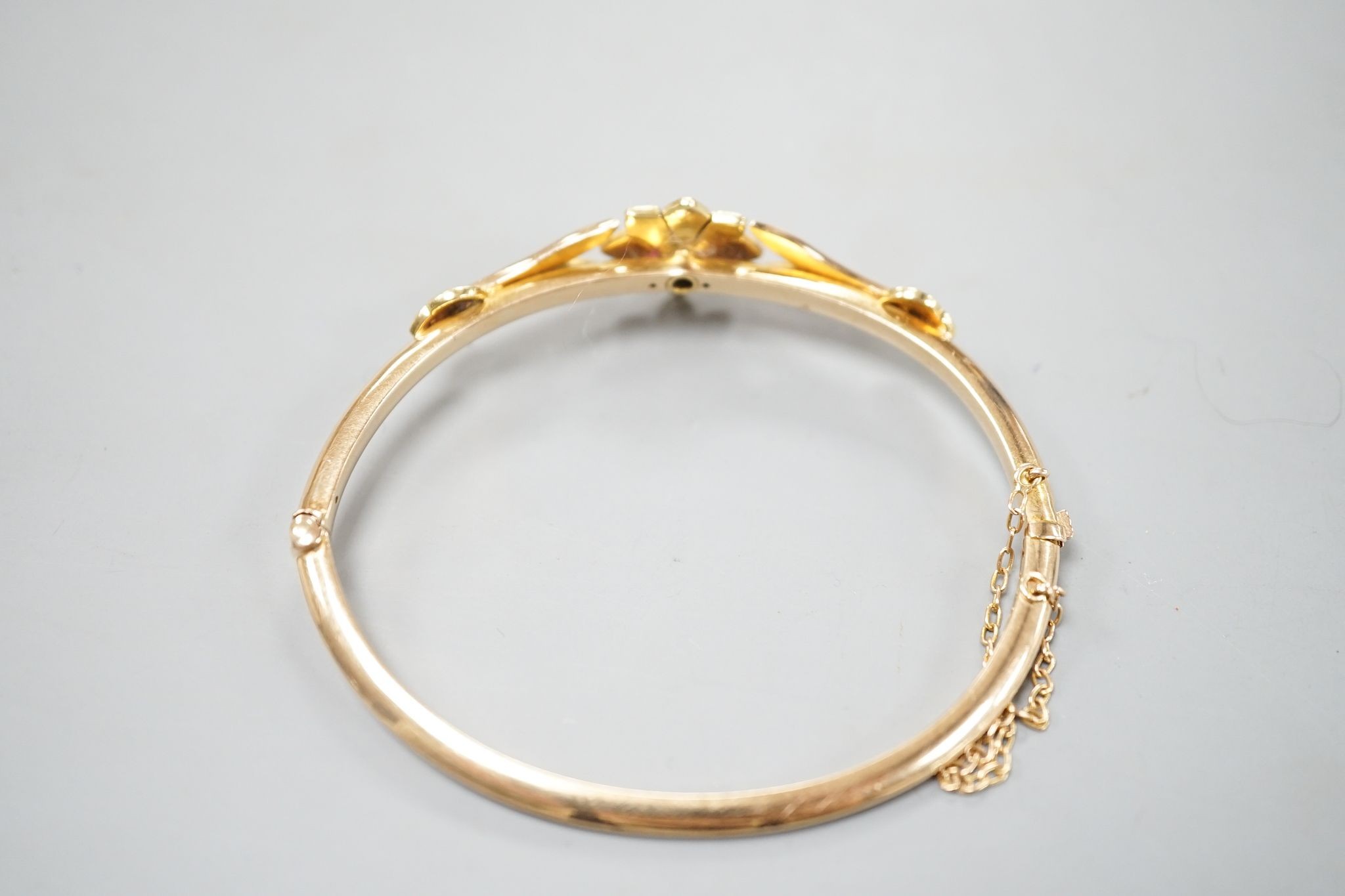 An early 20th century yellow meta diamond and seed pearl set hinged bangle, gross 9.5 grams.